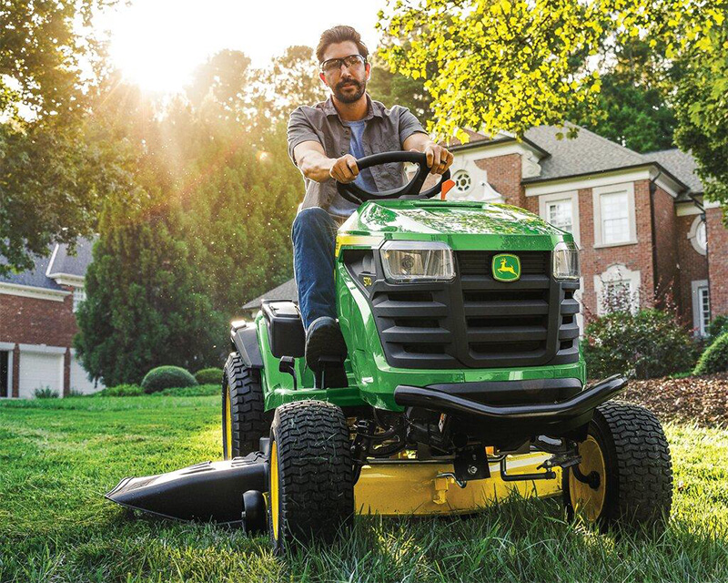A man mowing the lawn on his John Deere S170 Garden Tractor